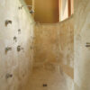 Shower clad in golden yellow travertine "Nuvolato Gold"